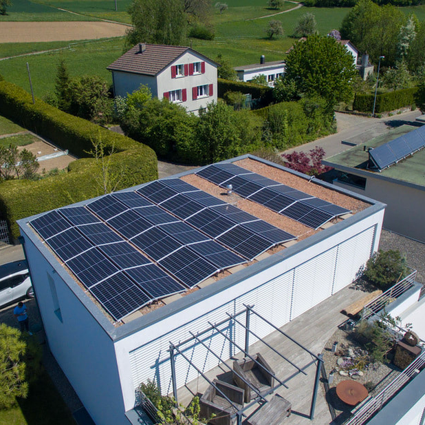 Luftaufnahme einer Flachdach Solaranlage auf einem Einfamilienhaus mit 10kWp Leistung.